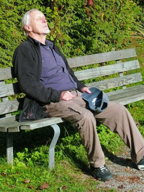 Man experiencing heat exhaustion sitting on a bench.