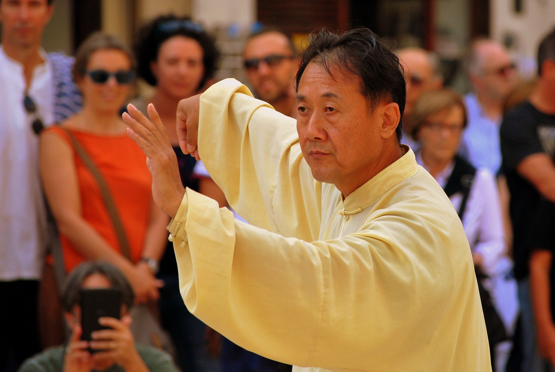 Man in yellow robe doing Tai Chi.