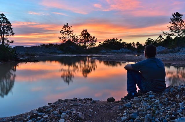 Man sitting near a lake.