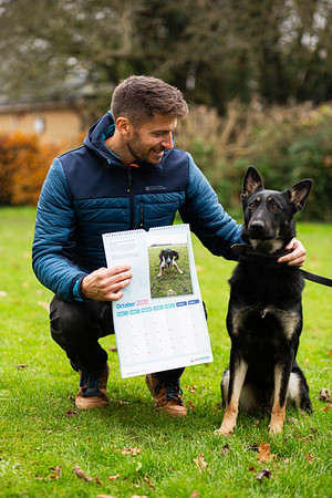 Presenter Rob Bell holding his Metfriendly calendar with a retired police dog