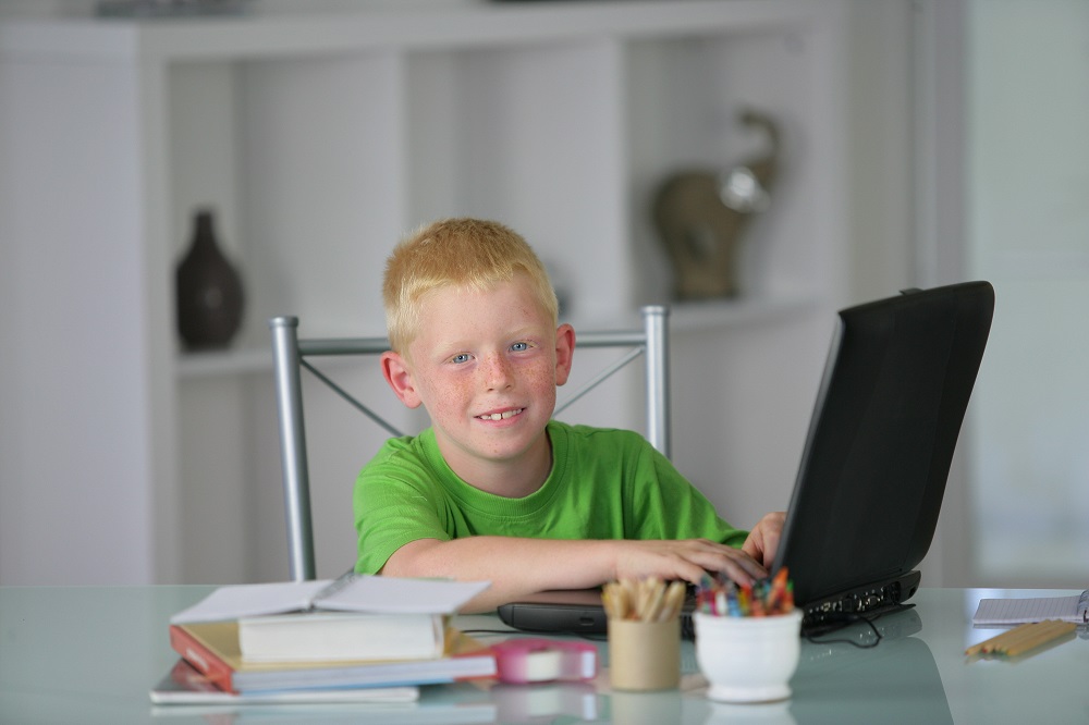 Little boy doing his homework in the kitchen