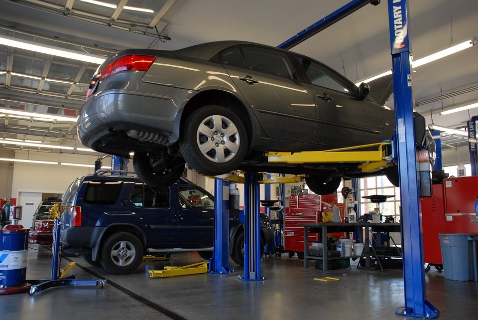 An image of two cars in an auto repair shop. When unexpected car repair expenses arise, employees with instant access to earned wages can cover unexpected expenses.