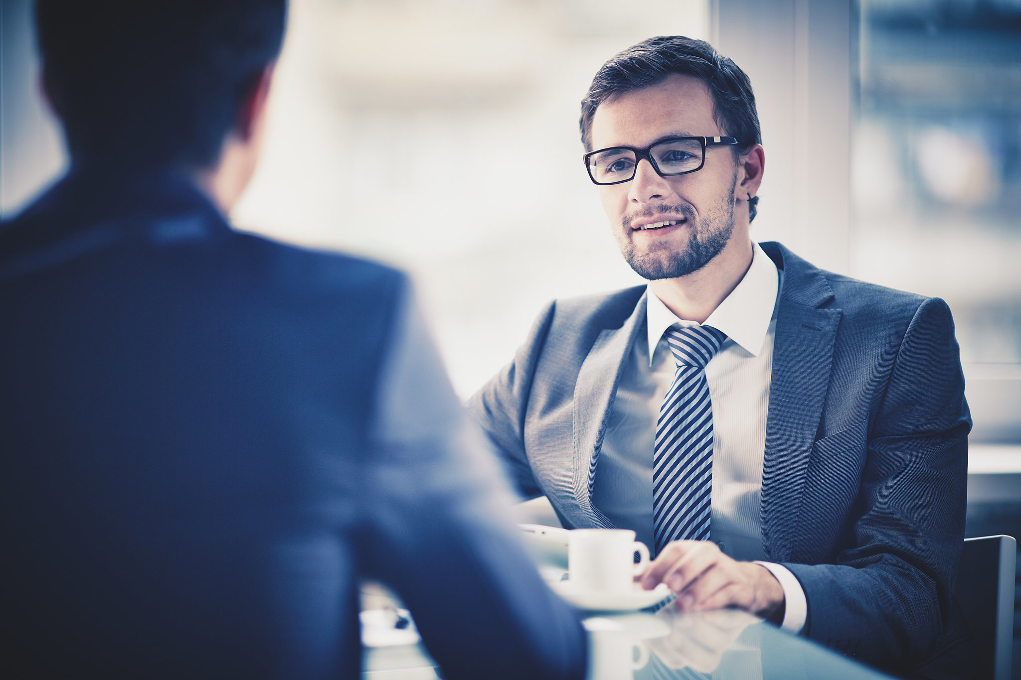 Business professional listening to a new recruit discuss employee engagement, suggesting a focus on core values to foster a sense of belonging.