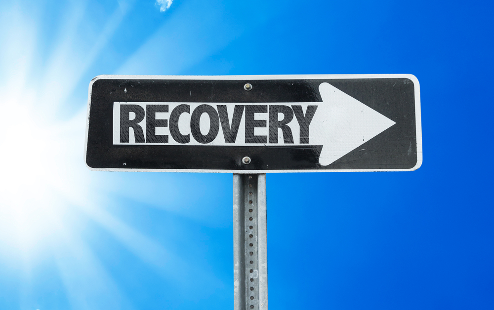 A road sign pointing to the right with the text "RECOVERY".
