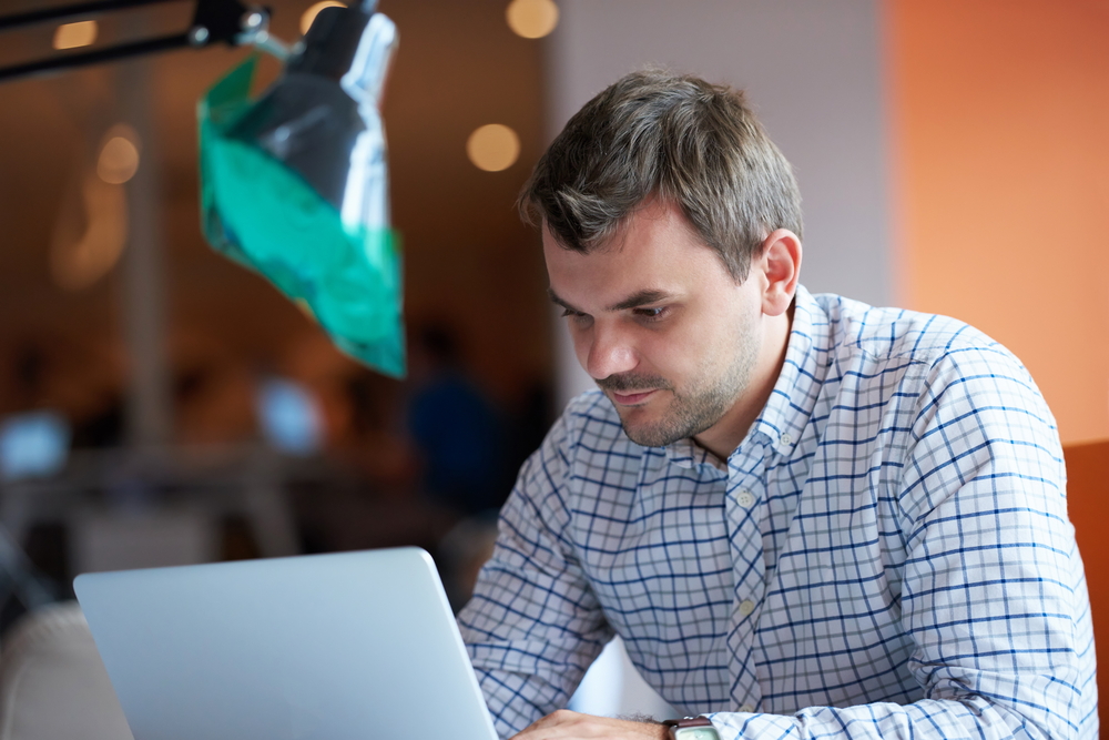 Employee engagement is a key factor in a company's success. This image shows a focused employee working on a laptop, demonstrating dedication.