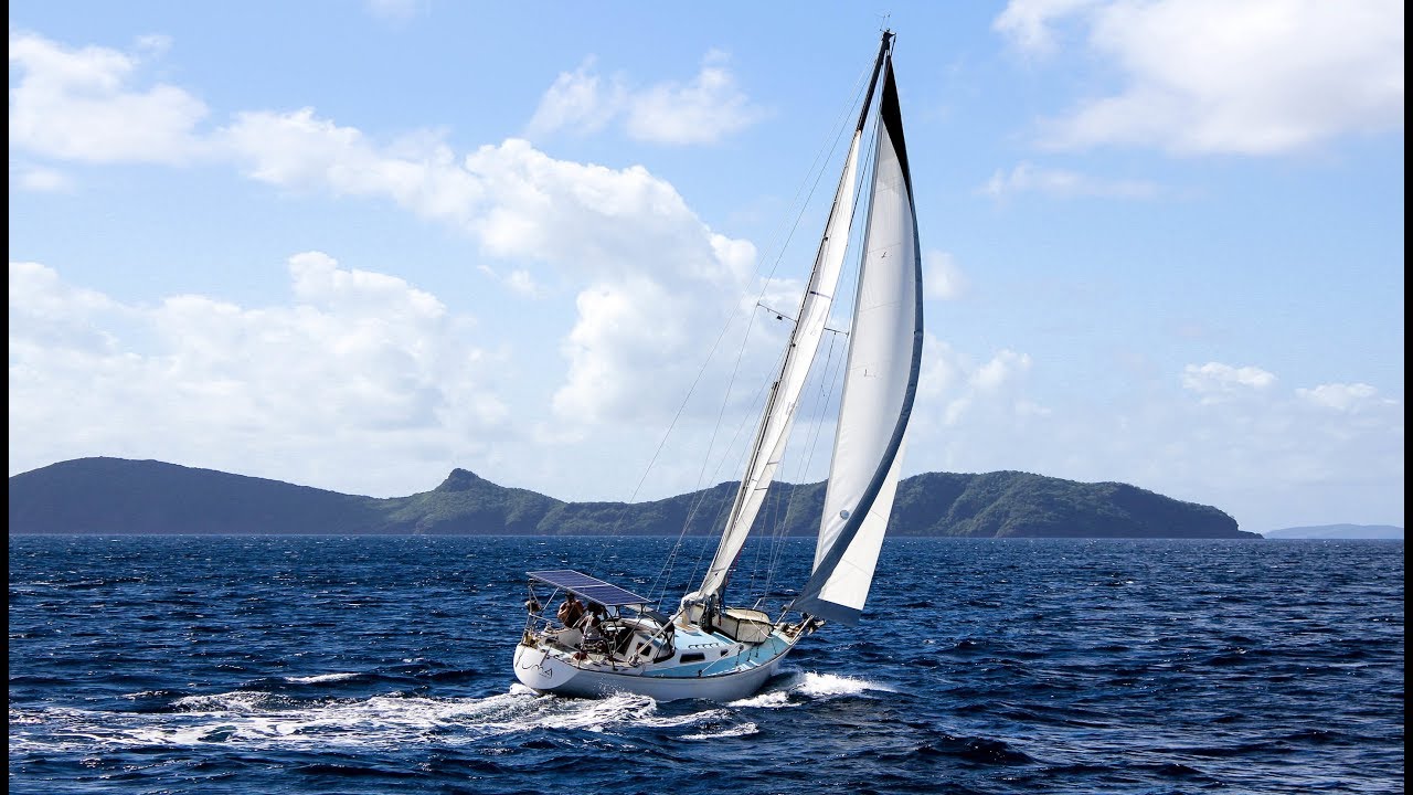 A sailboat on a wavy sea with mountains in the distance, illustrating how a strong organizational system and clear roles can improve employee engagement and calm.