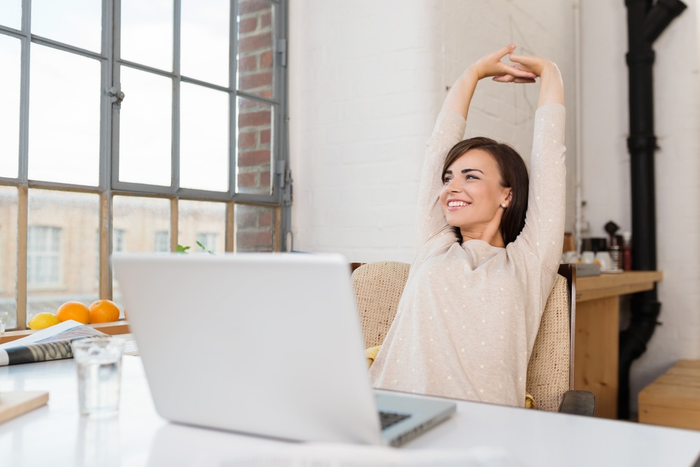 Happy relaxed young woman sitting at computer: Do these 3 things for success