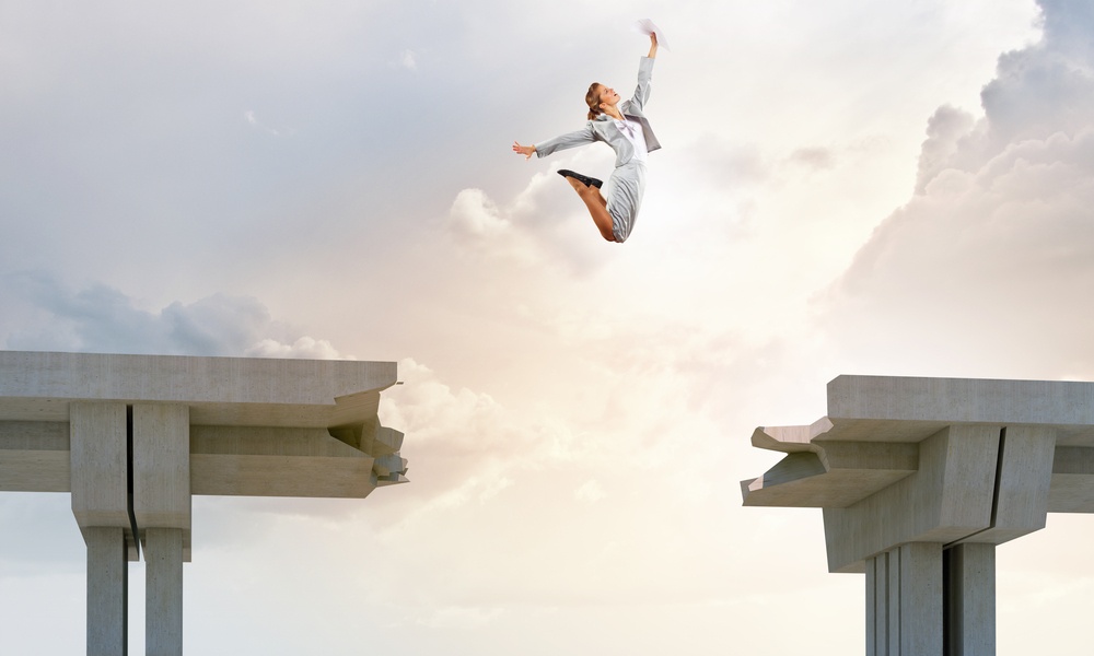 Young woman jumping over a gap in the bridge as a symbol of risk.jpeg