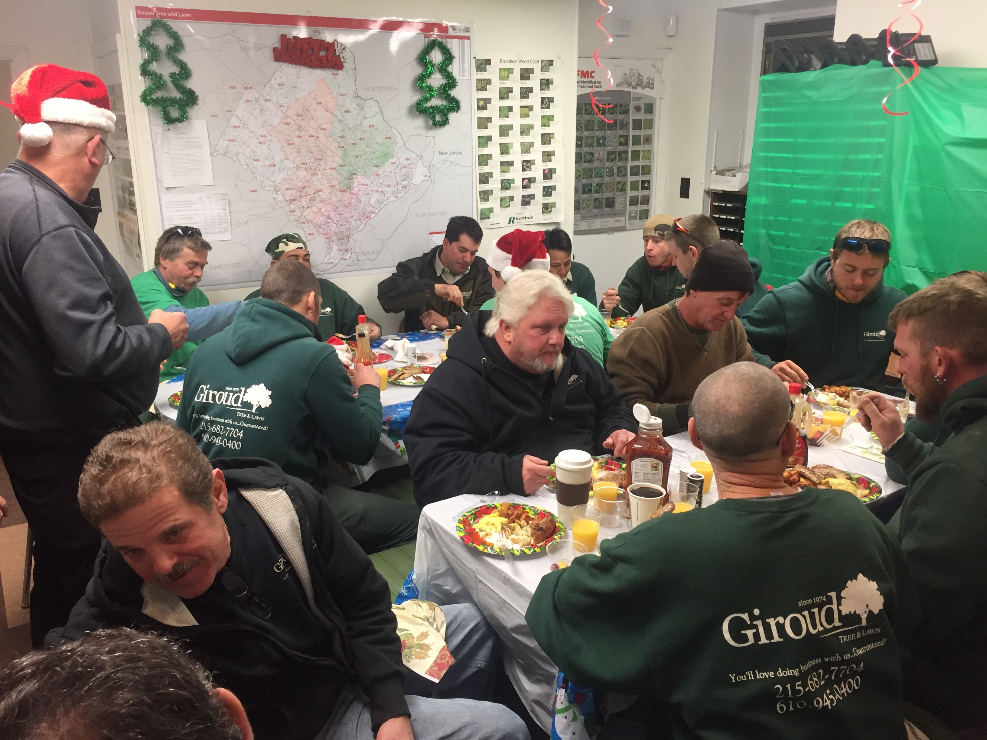 The field crew enjoys a holiday breakfast together as the office staff serves them.