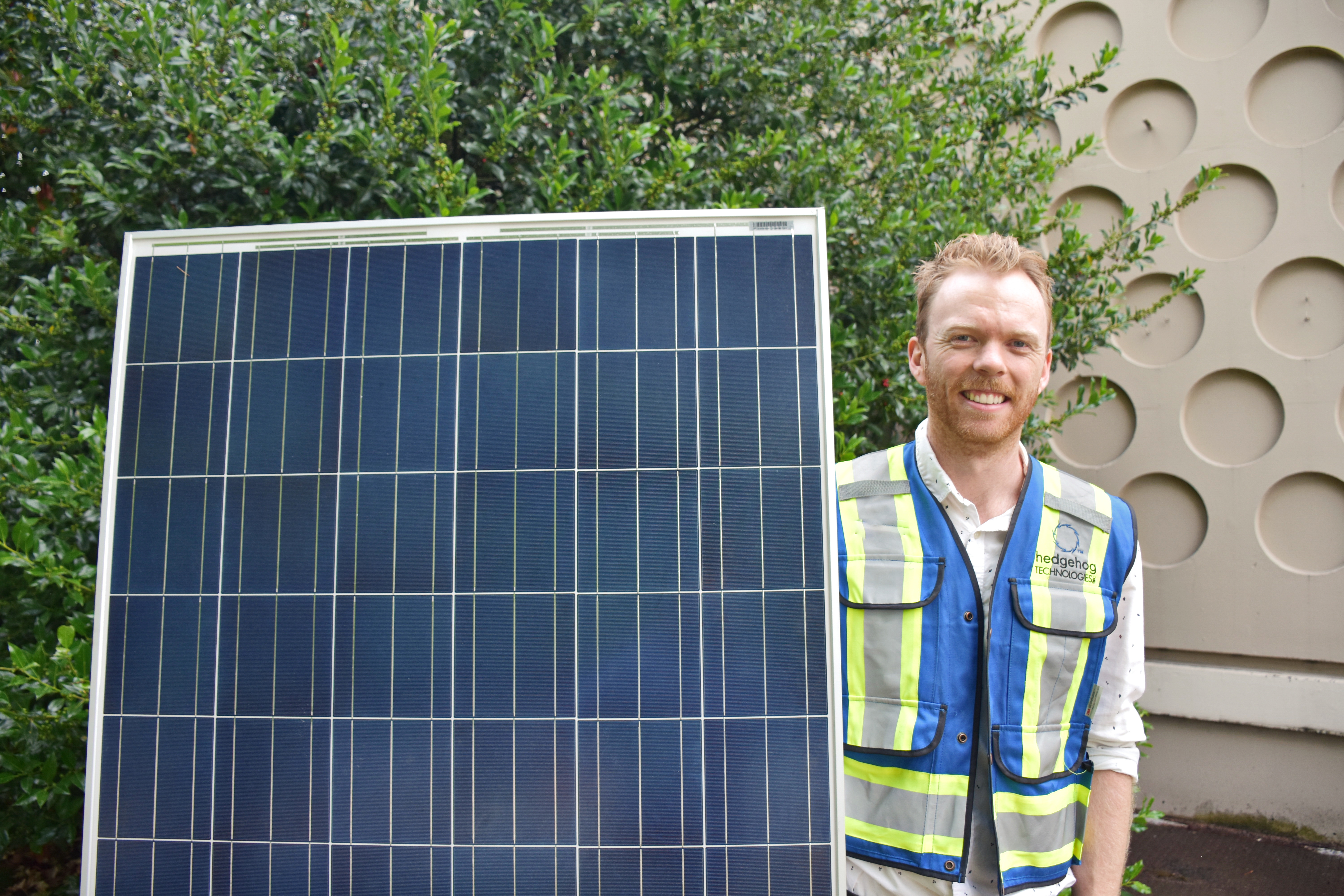 A co-op engineer holding a solar panel