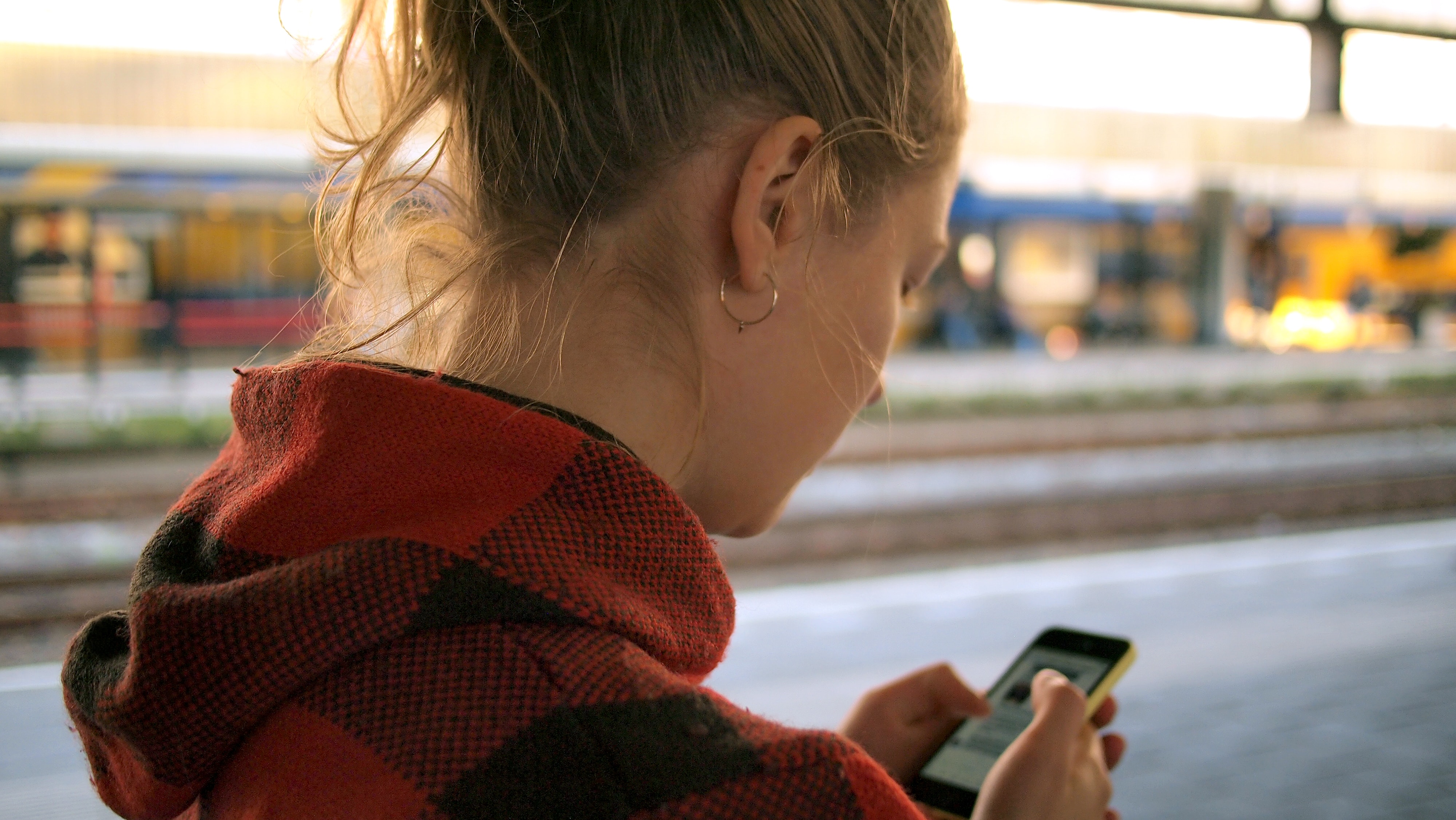 girl looking down at her phone, illustrating that human trafficking may be closer than you think