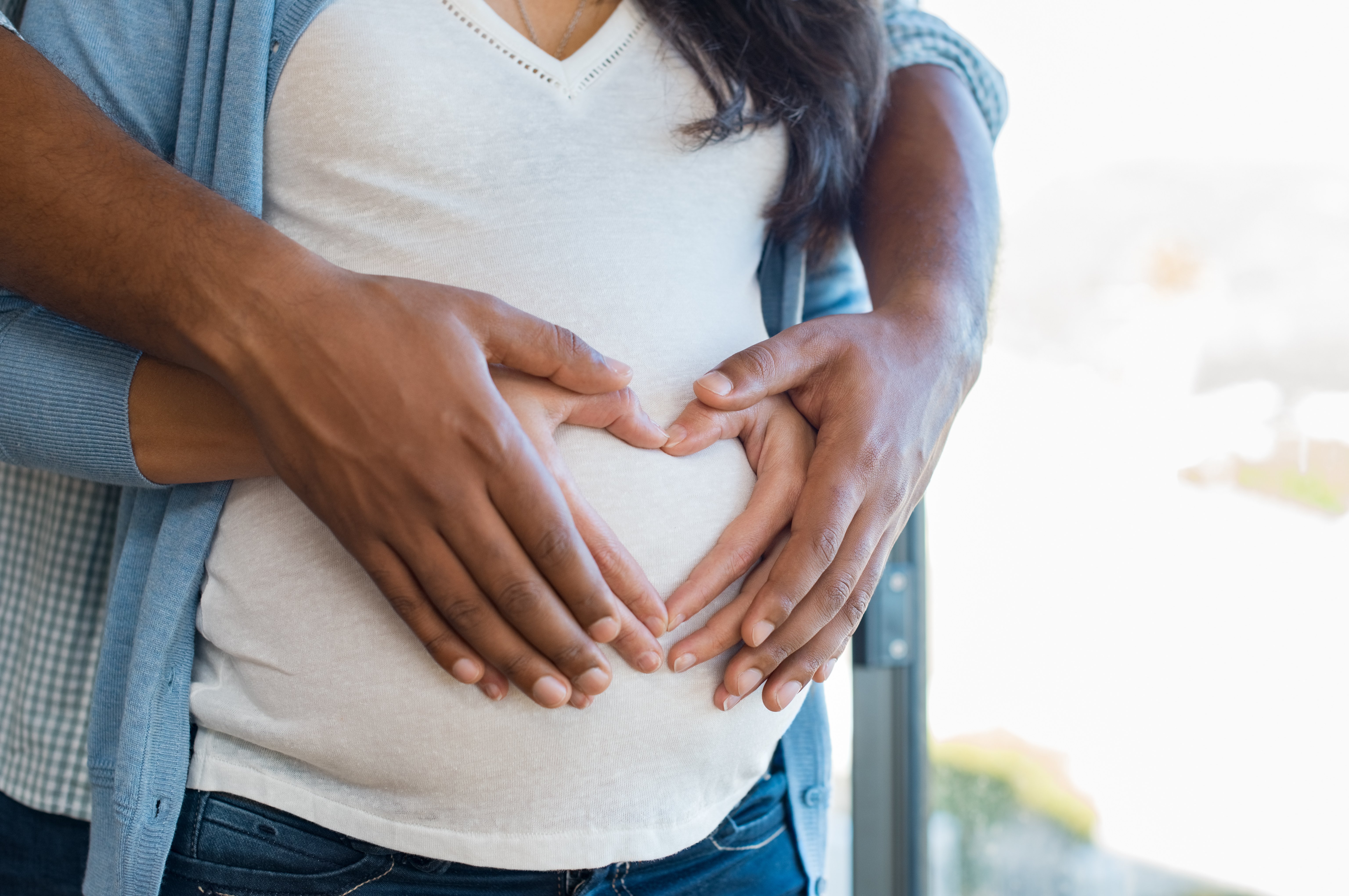 Pregnant couple touching stomach