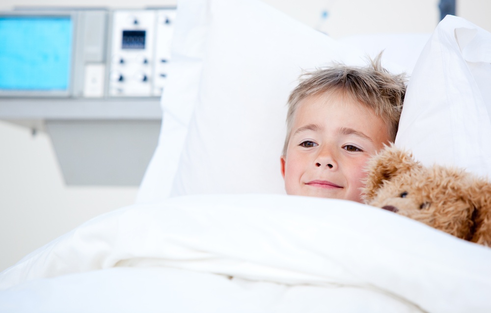 Portrait of a sick cute little boy lying in a hospital bed-1