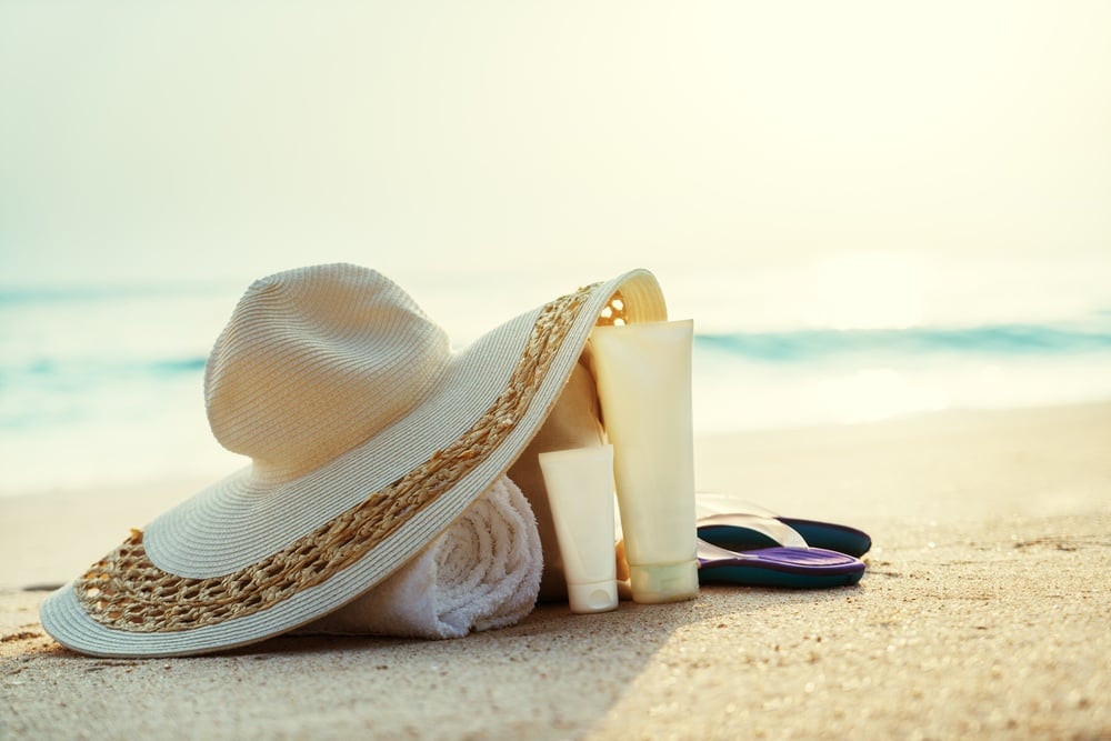 Sun lotion, hat with bag at the beach