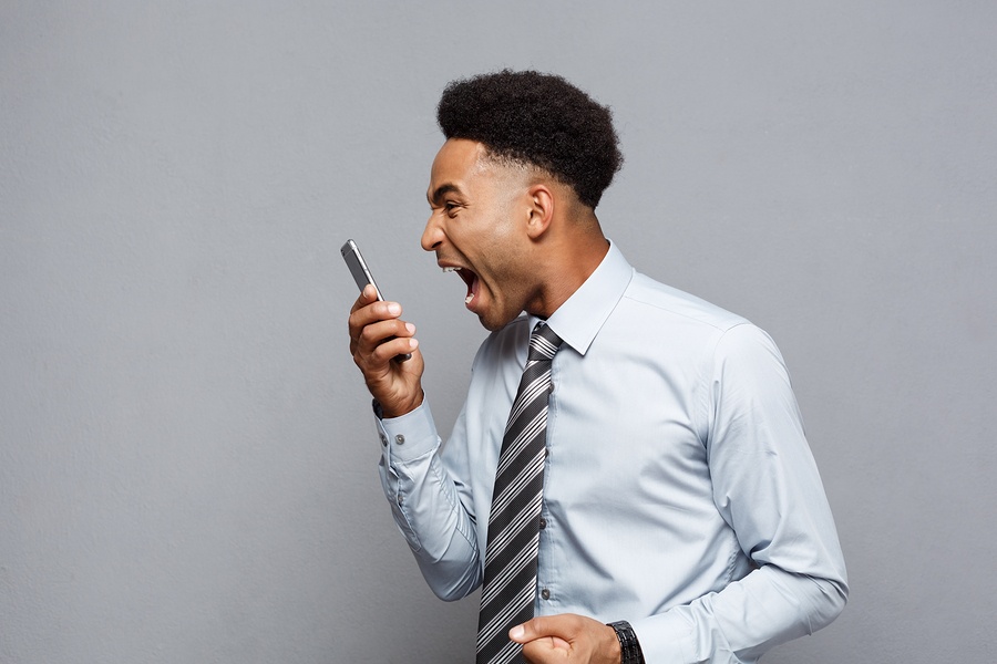 Stress signs Young Black man screaming into cellphone