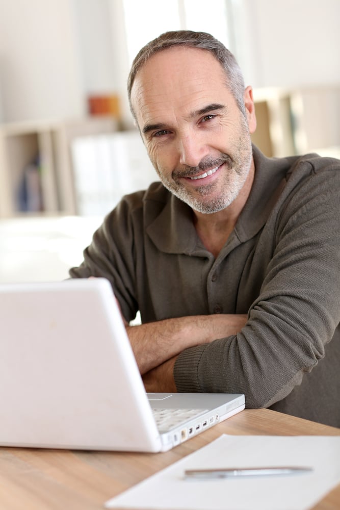 Senior man working from home with laptop computer