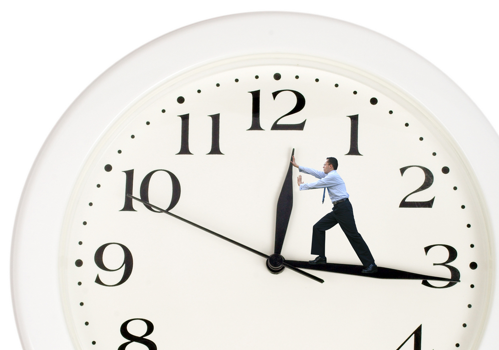 Time management , clock hands pushed back by a man