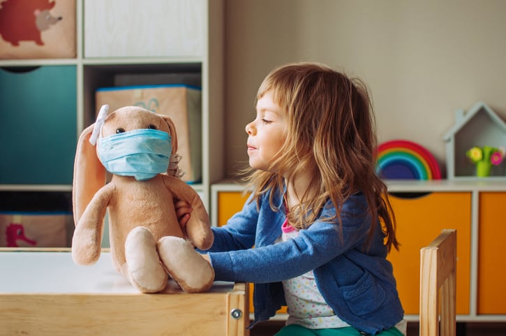 girl-looking-at-stuffed-bunny-with-a-mask