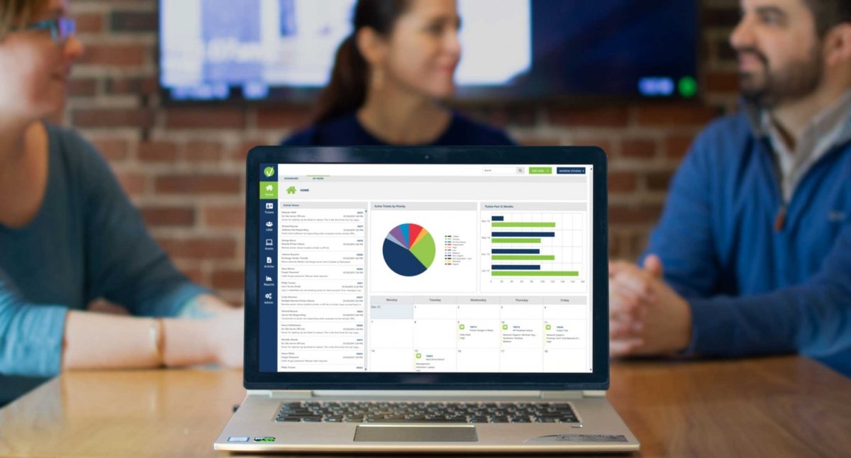 laptop-showing-vivantio-dashboard-with-three-people-talking-in-the-background