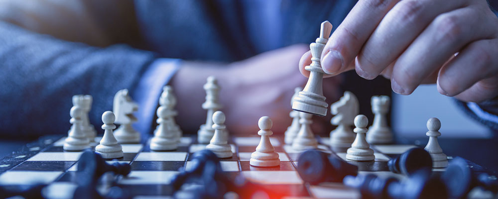 resources-library-featured-image-a-hand-placing-a-chess-piece