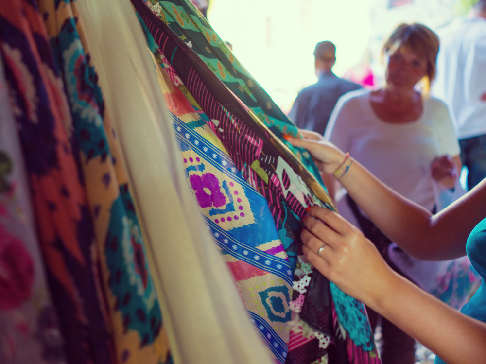 Woman choosing clothes at flea market