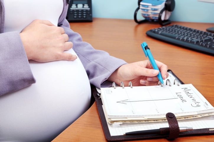pregnant woman viewing calendar of her maternity leave