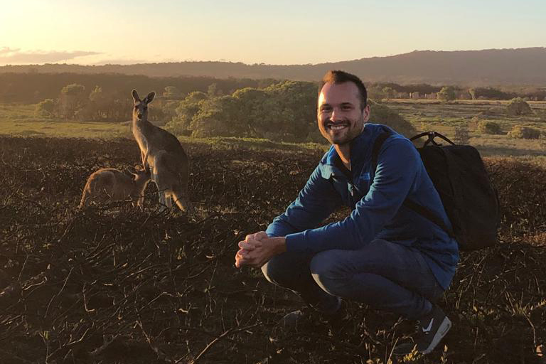 André Sauser in Australien mit einem Kängeru im Hintergrund