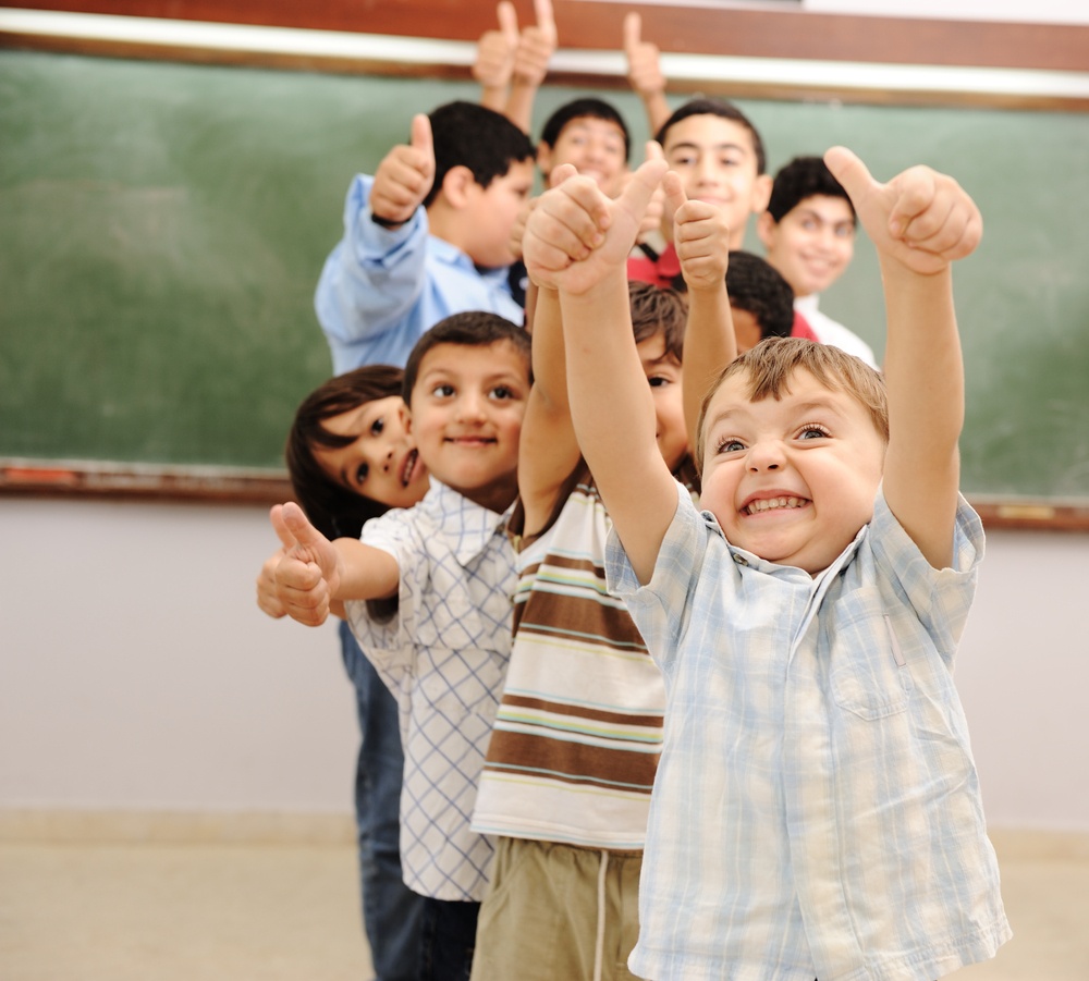 Children at school classroom with thumbs up. Source: Shutterstock