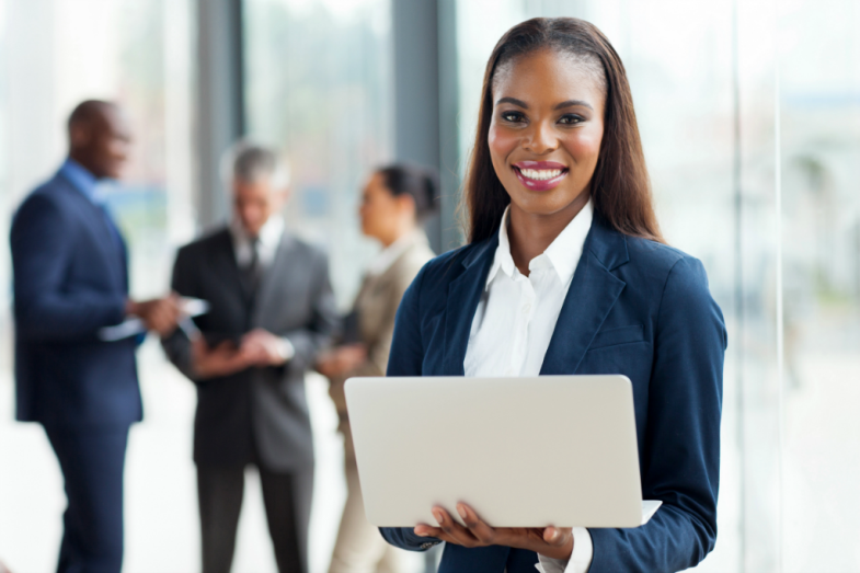 Successful Business Woman Holding a Laptop | SupportingStrategiesFranchise.com