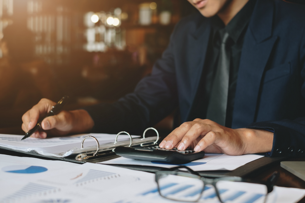 Man at Desk with Papers and Calculator | SupportingStrategieFranchise.com