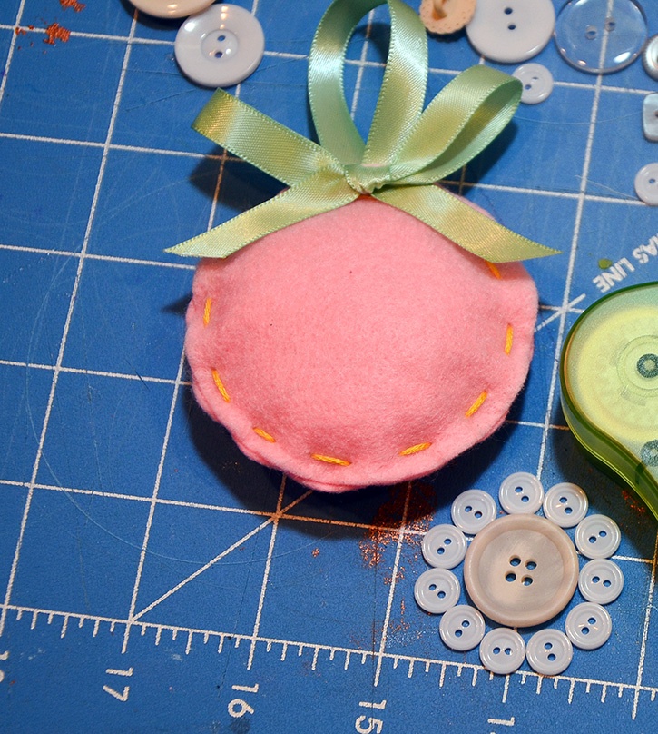 glue-dots-felt-ornament-set-stuffed-with-ribbon-buttons-laid-out.jpg
