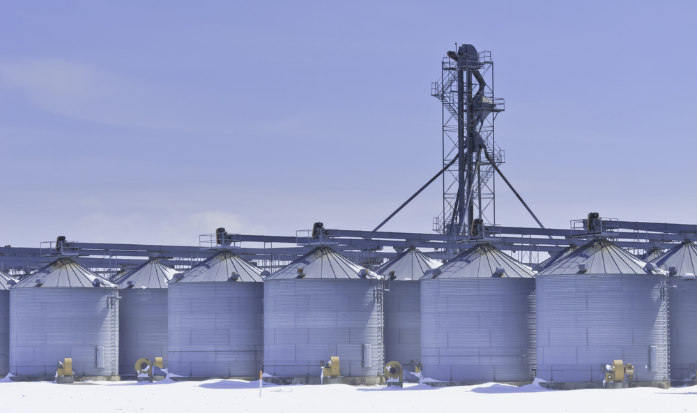 Steel grain silos and control tower above snow in March, central Illinois