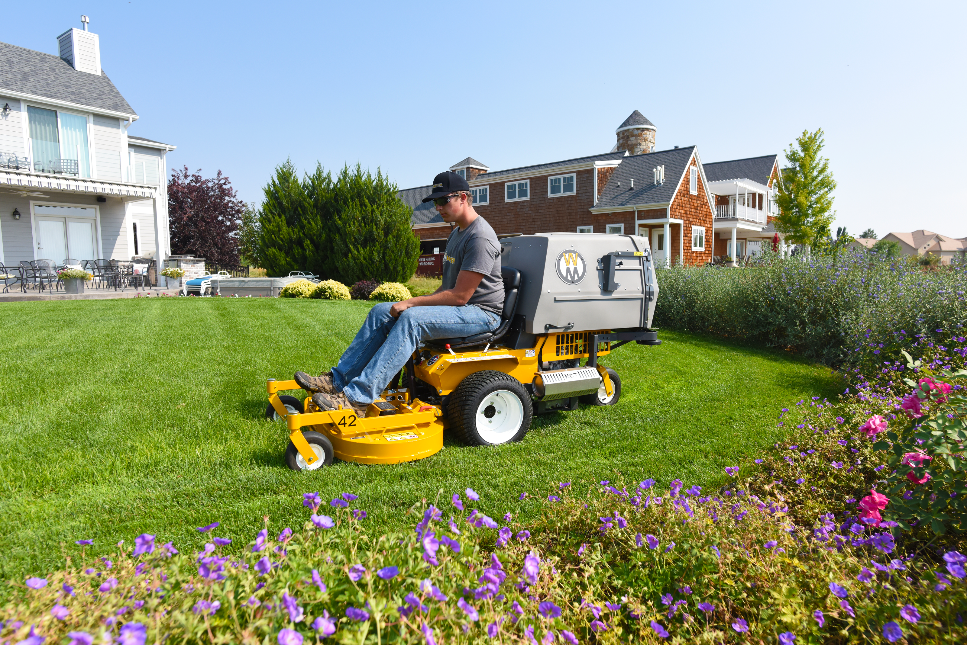 Walker C19 Mowing A Lush Lawn Beside A Flowering Garden Bed