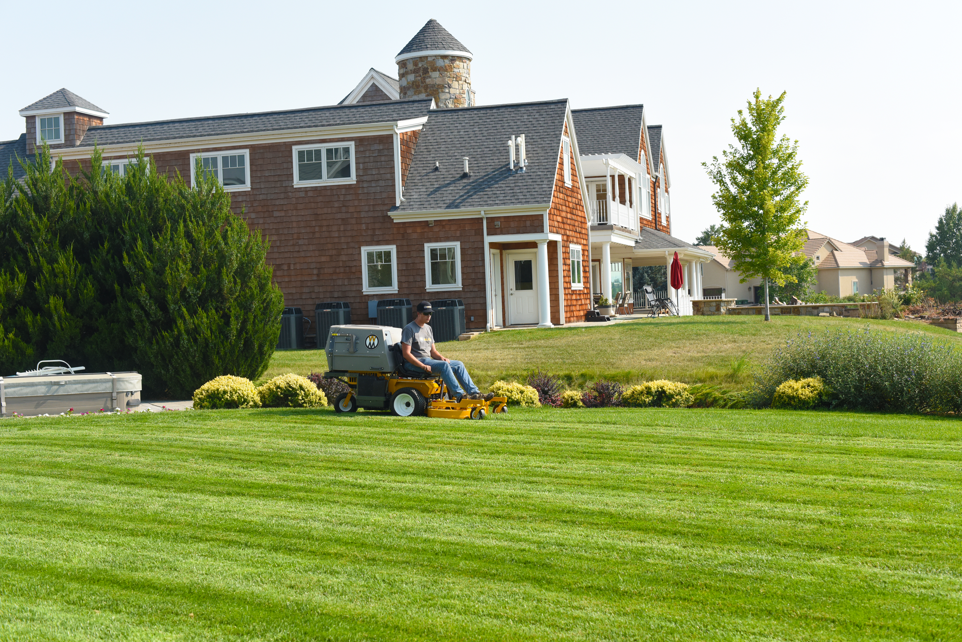 Walker C19 Mowing A Broad, Neatly Striped Lawn In Front Of A Landscaped Residential Property