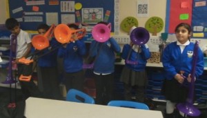 Children play their pBones in the classroom.