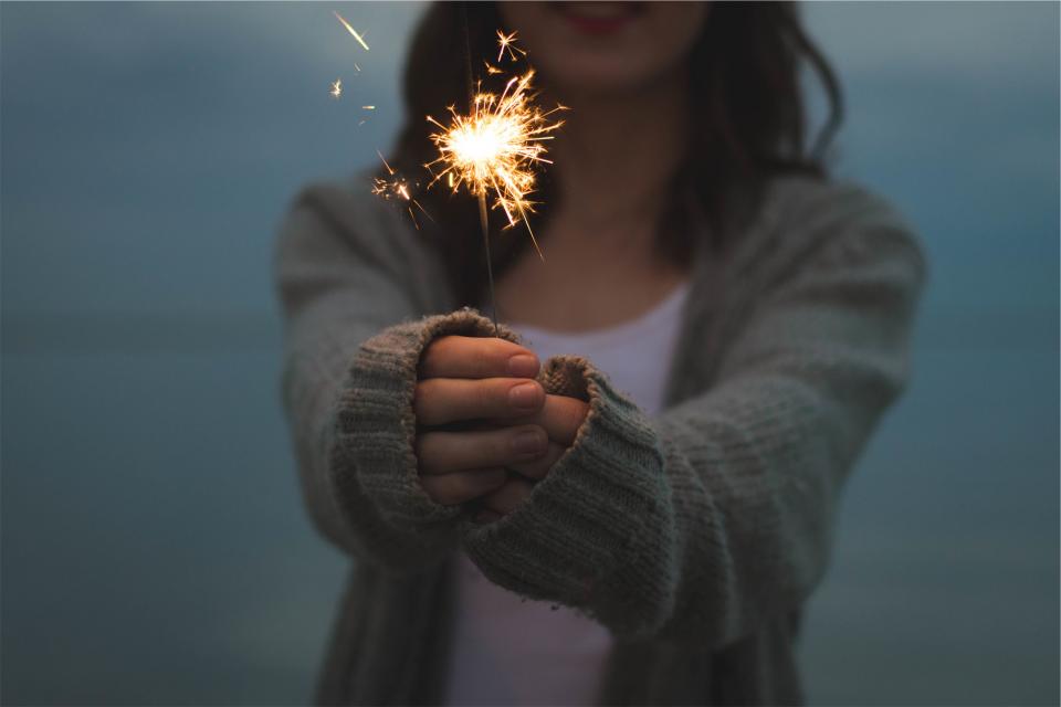 Millennial holding out hands with sparkler
