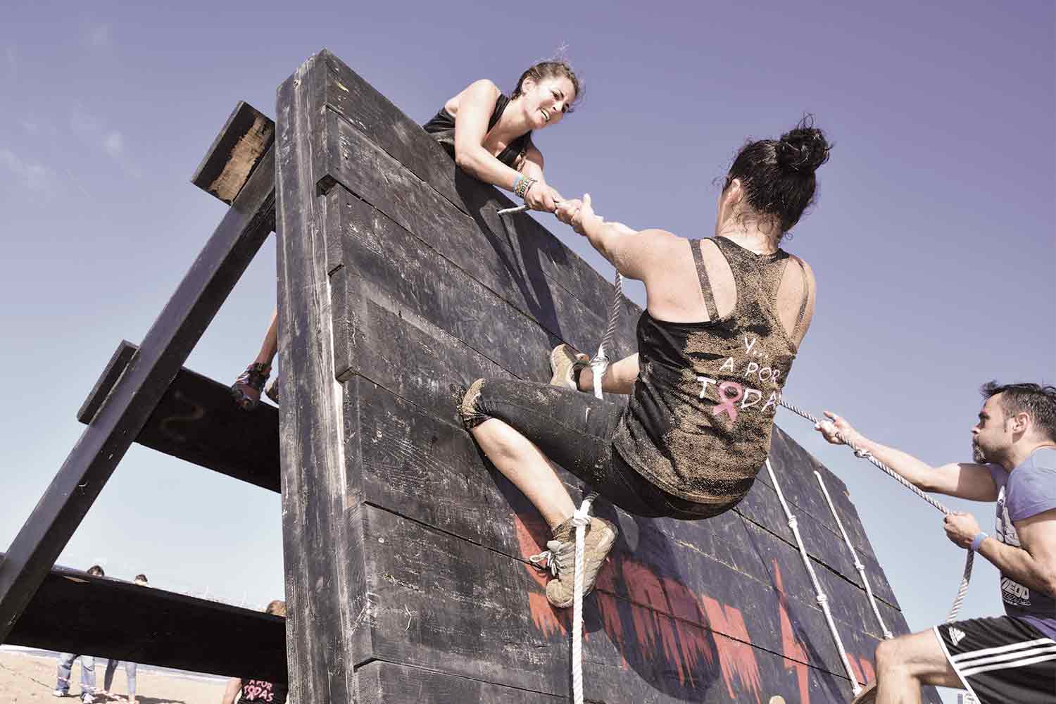 Obstacle Course Race Diet - Woman OCR racer helping another racer up a wall