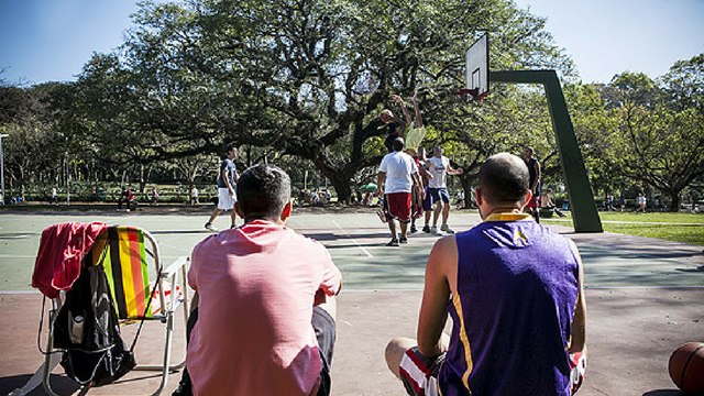 Grupo de amigos jogando basquete em uma quadra pública ao ar livre