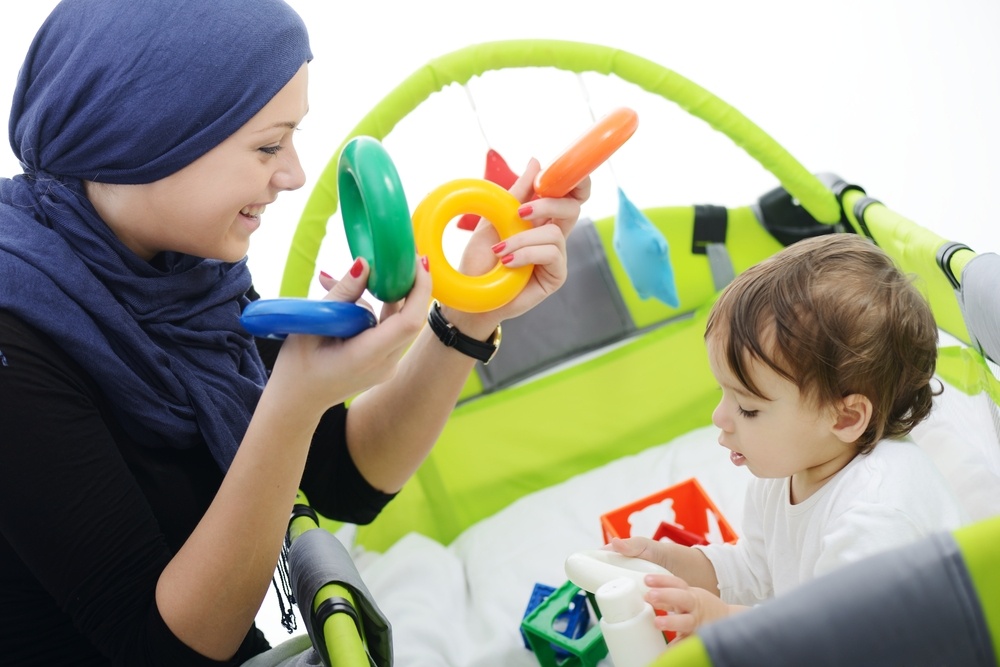 Arabic Muslim mother playing and taking care of her baby.jpeg