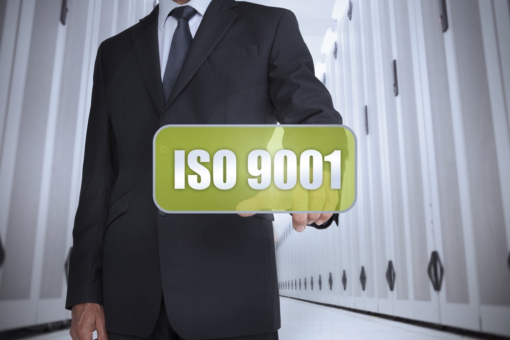 Businessman in a data center selecting a green label with iso 9001 written on it.jpeg
