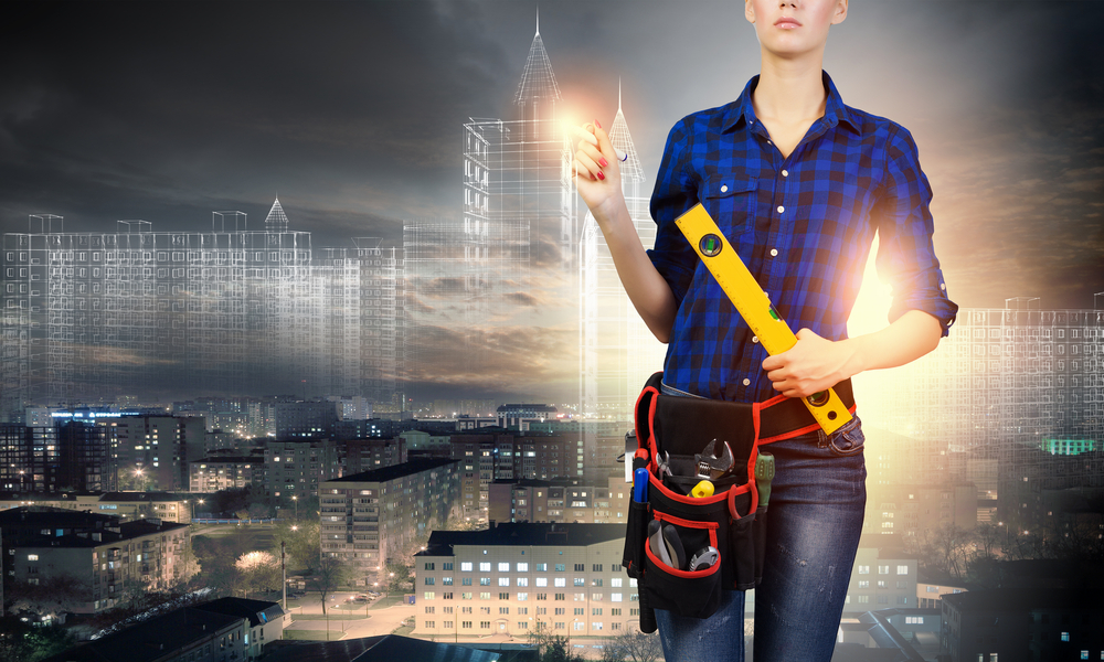 Young pretty woman engineer with tool belt on waist