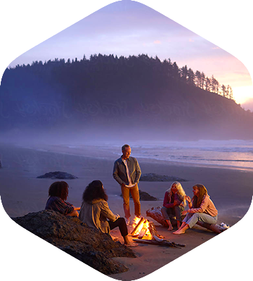 A group of young adults enjoying a campfire on the beach