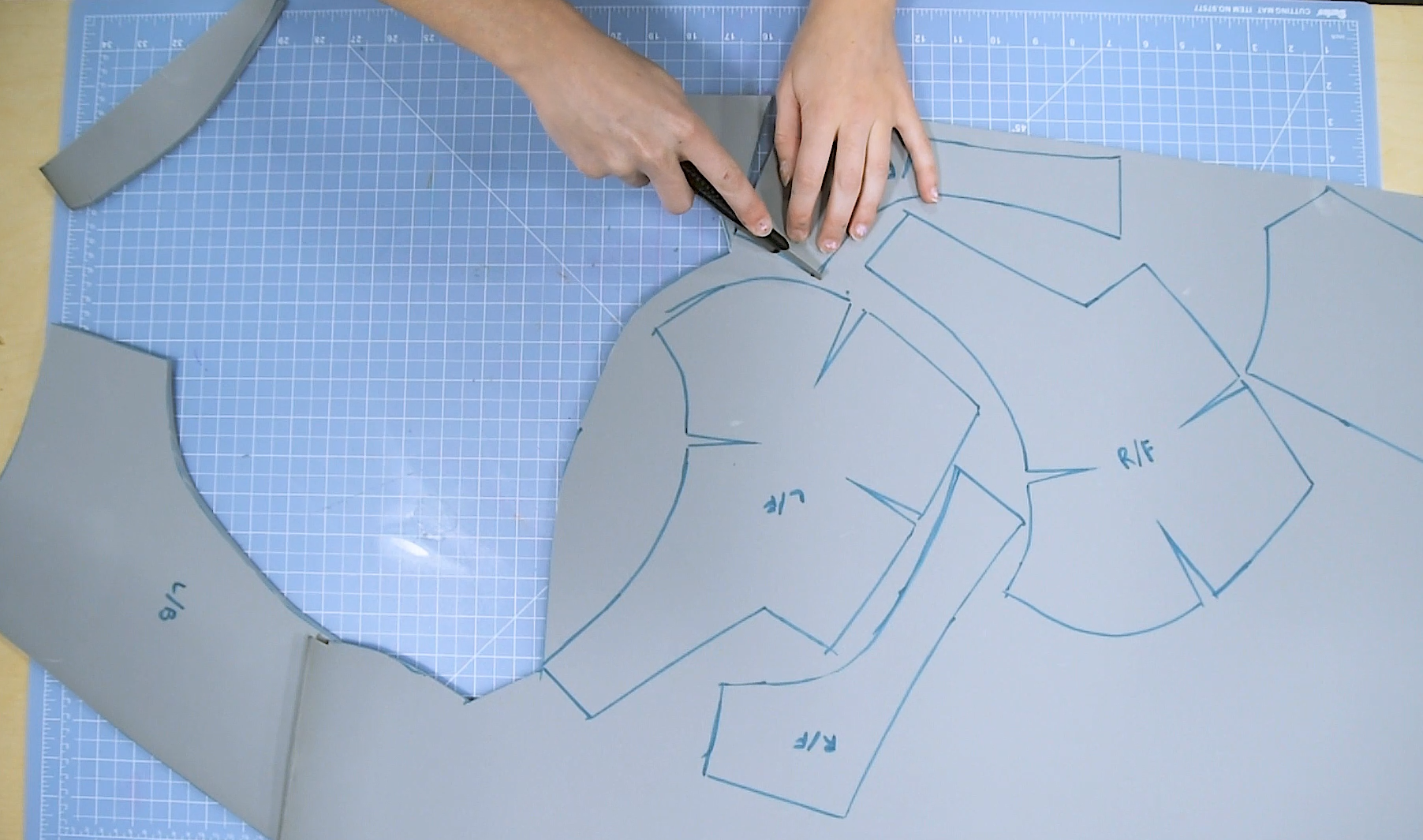 Cosplayer cutting out foam pattern pieces for armor