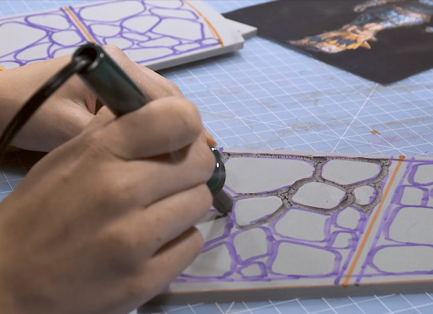 Cosplayer carving scales into foam cosplay armor using hot soldering iron