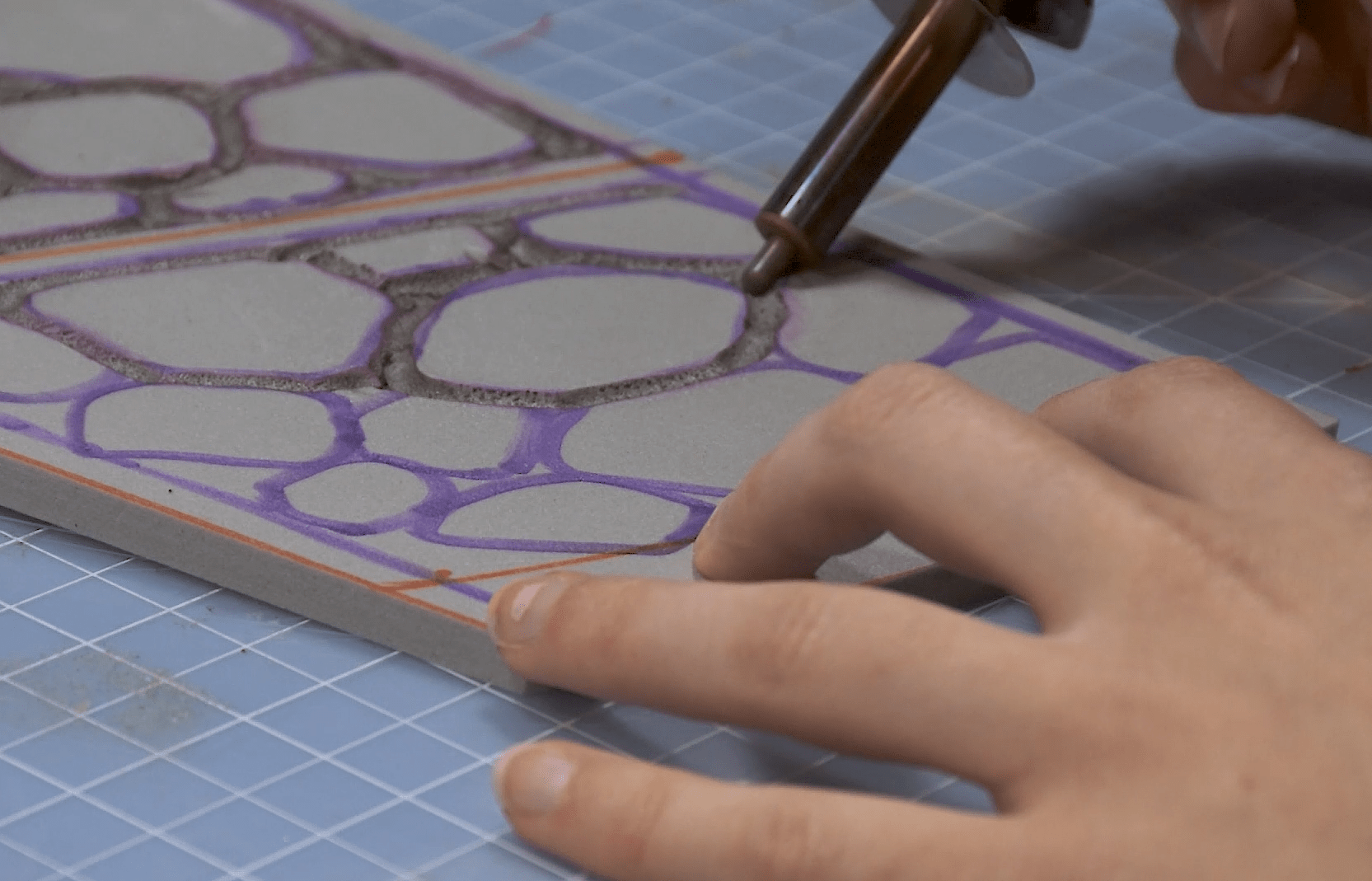 Cosplayer carving dragon scales into EVA foam using a soldering iron
