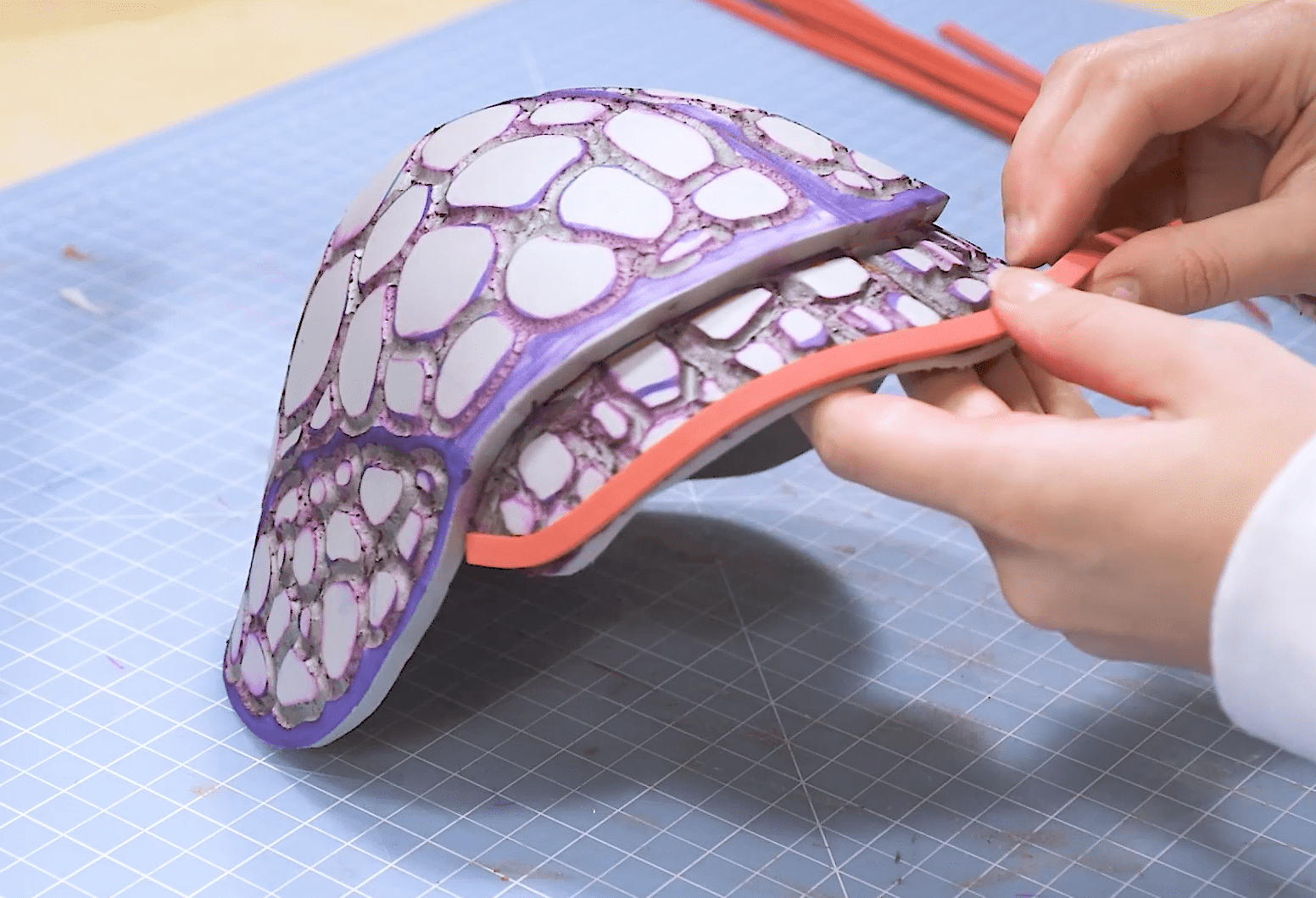 Cosplayer adding scales and foam details to EVA armor pauldron
