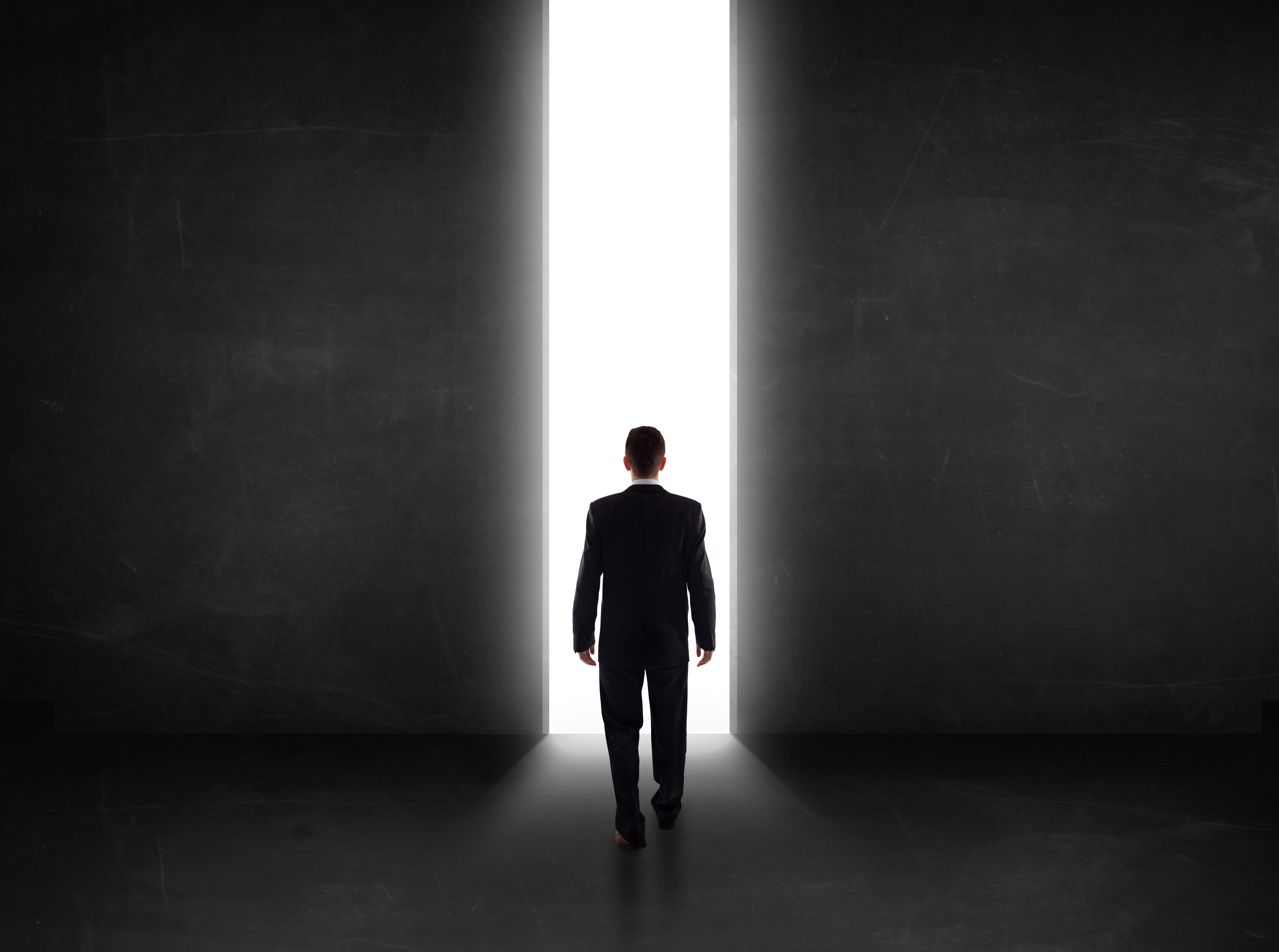 Business person looking at wall with light tunnel opening