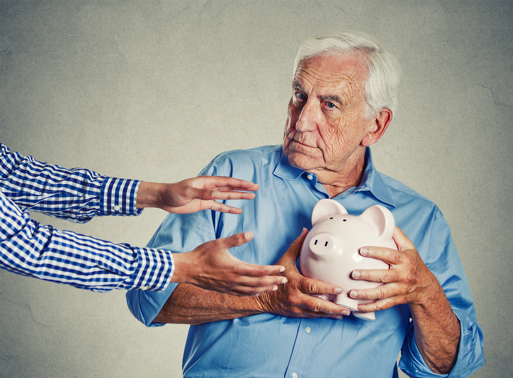 Senior man holding piggy bank suspicious protecting savings