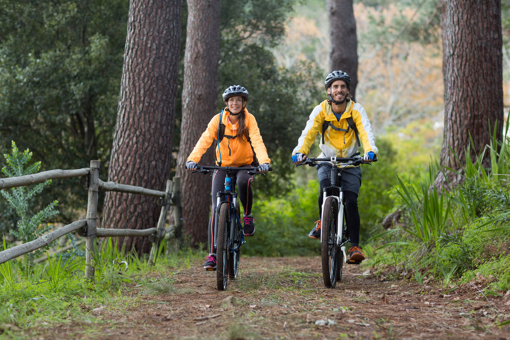 Biker couple cycling in countryside forest