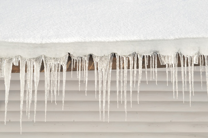 Snow and icicles cling to roof